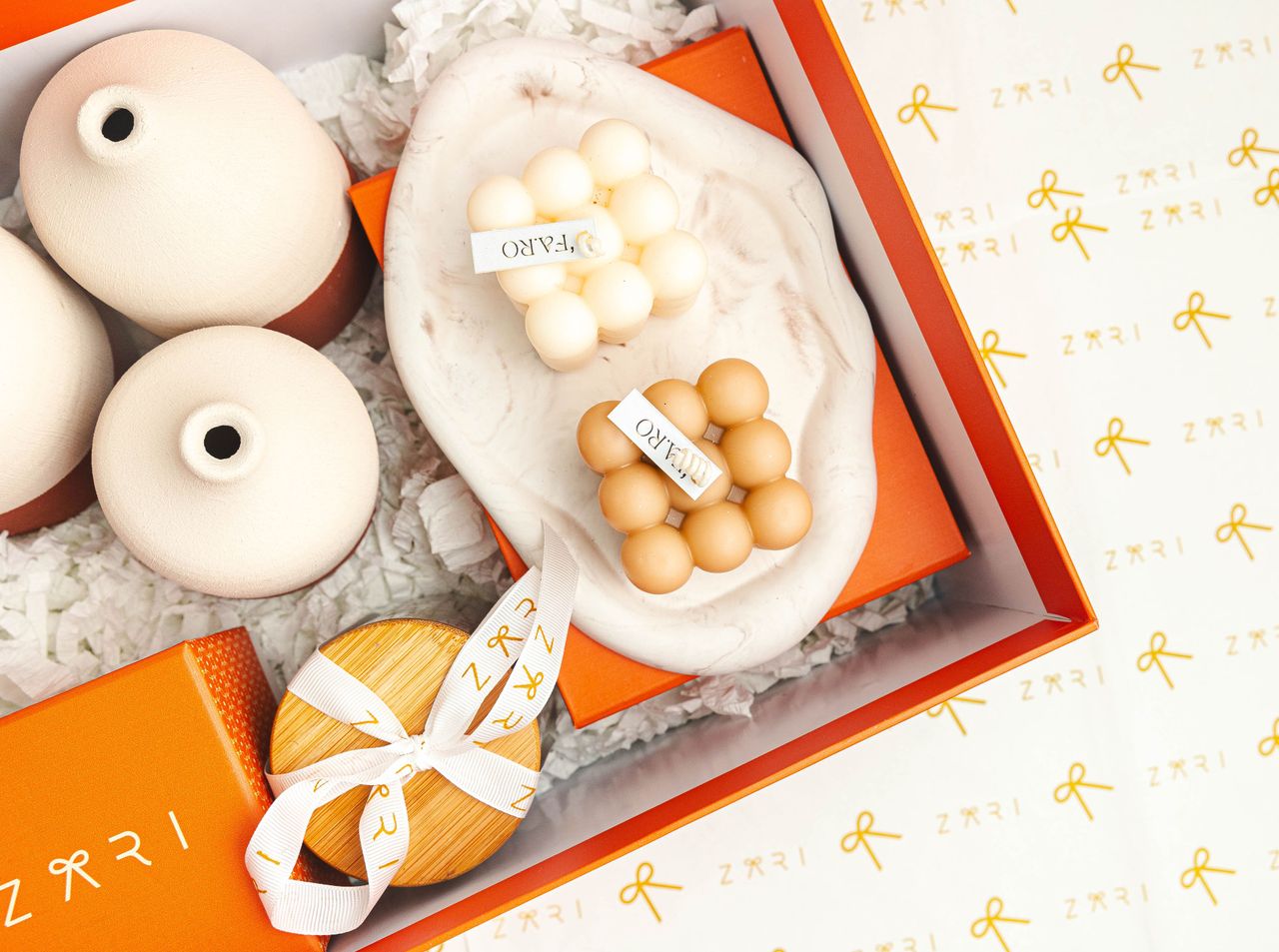 Elegant gift box featuring artistic vases, beads, and branded packaging for home decor.
