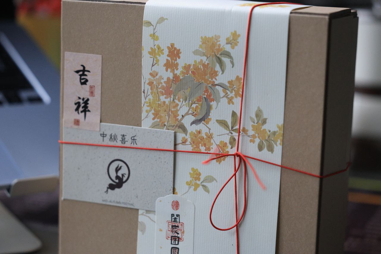 A beautifully wrapped gift box featuring floral design and Chinese calligraphy, perfect for festive occasions.