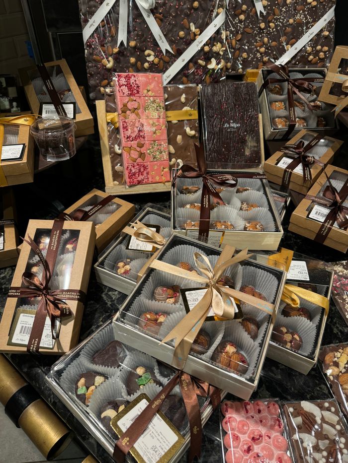 A luxurious display of gourmet chocolate gift boxes with decorative ribbons and packaging.