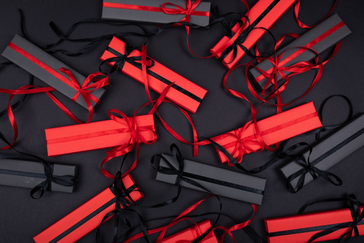 Top view of elegantly arranged red and black gift boxes with ribbons, creating a festive and sophisticated look.